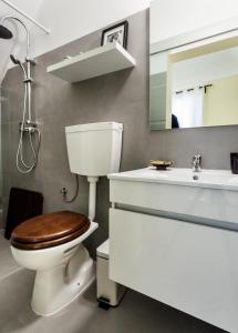 een badkamer met een toilet, een wastafel en een spiegel bij Alfar Aqueduct - Évora House in Évora