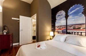 a bedroom with a bed with a view of a city at Alfar Aqueduct - Évora House in Évora