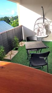 a patio with a table and chairs and a bird cage at Hedeun studio in Fort-de-France