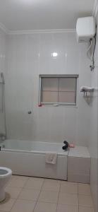 une salle de bain blanche avec une baignoire et des toilettes dans l'établissement Hampton - Resorts, à Hohoe