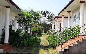 une maison avec des escaliers et des palmiers devant dans l'établissement Hampton - Resorts, à Hohoe 6 autres photos