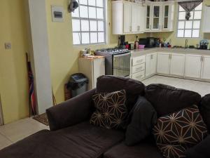 ein Wohnzimmer mit Couch und Küche in der Unterkunft J's vacation home in Wallhouse