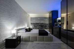 a bedroom with a large white bed and a wall at Gramsci Prestige Apartment in Bologna