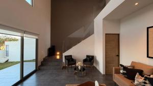 a living room with a couch and chairs and a staircase at Hermosa Casa en San Miguel con cancha de pádel in San Miguel de Allende