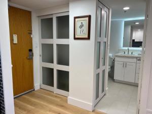 baño con puertas correderas de cristal y lavamanos en Ilikai Tower 1936 condo, en Honolulu