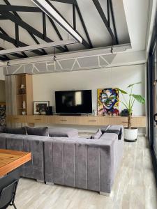 - un salon avec un grand canapé et une télévision à écran plat dans l'établissement Wabi Sabi, à Johannesbourg