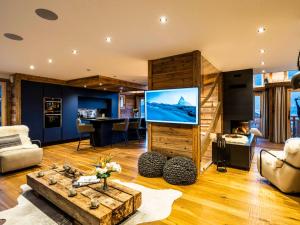 ein Wohnzimmer mit einem großen Flachbildfernseher in der Unterkunft Chalet Nyumbani : luxe et confort, skis aux pieds, proche lac et pistes, sauna, jacuzzi, solarium - FR-1-598-66 in Les Gets