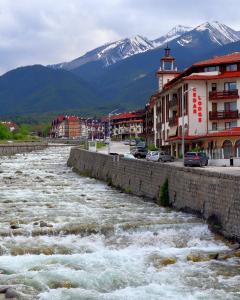 een rivier in een stad met bergen op de achtergrond bij CEDAR LODGE LUX Apartment B11 in Bansko