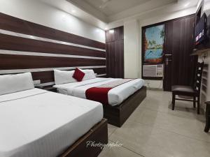 a hotel room with two beds and a tv at Hotel Blu Bird in New Delhi