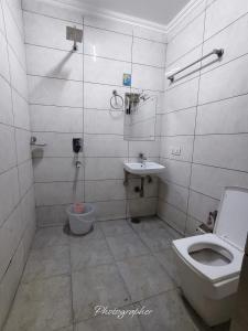 a bathroom with a toilet and a sink at Hotel Blu Bird in New Delhi