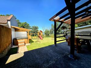 einen Hinterhof mit einem Picknicktisch und einem Spielplatz in der Unterkunft Dom z jacuzzi, house with a hot tub in Gardna Wielka