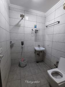 a bathroom with a toilet and a sink at Hotel Blu Bird in New Delhi