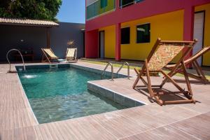 two lounge chairs and a swimming pool next to a house at Zen Spa Houses in São Miguel dos Milagres