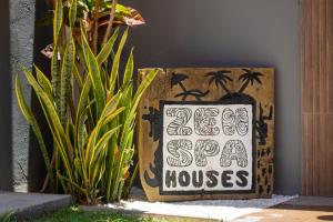 a sign that says zero super houses next to some plants at Zen Spa Houses in São Miguel dos Milagres