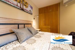 ein Schlafzimmer mit einem Bett mit einem hölzernen Kopfteil in der Unterkunft Apartamento Las Góndolas Playa ALOJAMIENTOS VISTAMAR in Almuñécar + 35 Fotos