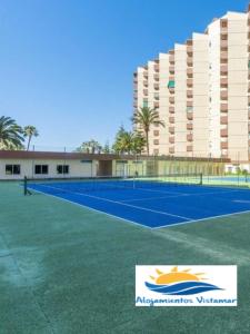ein Tennisplatz vor einem Gebäude in der Unterkunft Apartamento Las Góndolas Playa ALOJAMIENTOS VISTAMAR in Almuñécar