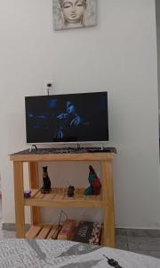 a television on a wooden stand with a tv at Duplex La Luna in Mar del Tuyú