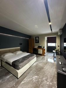 une chambre avec un grand lit et un bureau dans l'établissement La Mirage Suites & Apartments, à Tirana