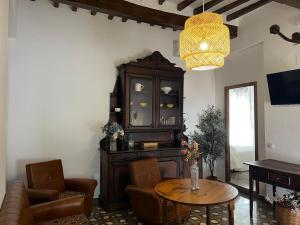 ein Wohnzimmer mit einem großen Schrank und einem Tisch in der Unterkunft Alojamientos El Carmen in Ugíjar