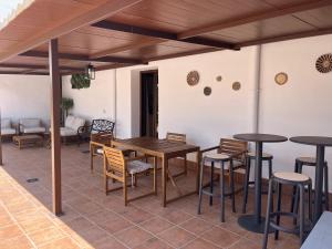 eine Terrasse mit einem Tisch, Stühlen und einem Sofa in der Unterkunft Alojamientos El Carmen in Ugíjar