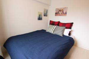 una camera da letto con un letto blu con due cuscini di Pine Hills Minoshima - Vacation STAY 12181 a Sumiyoshi