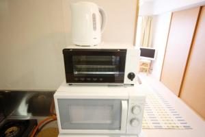 un forno a microonde bianco posizionato sopra un forno a microonde bianco di Pine Hills Minoshima - Vacation STAY 12181 a Sumiyoshi Altre 37 foto
