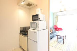 una camera con forno a microonde e frigorifero di Pine Hills Minoshima - Vacation STAY 12181 a Sumiyoshi
