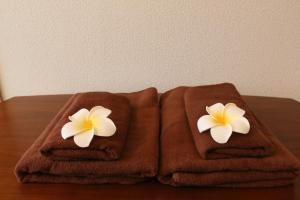 due asciugamani con fiori su un tavolo di Pine Hills Minoshima - Vacation STAY 12181 a Sumiyoshi