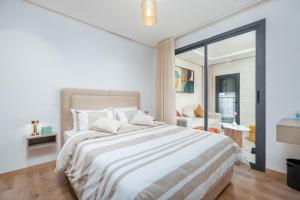 ein weißes Schlafzimmer mit einem großen Bett und einem Fenster in der Unterkunft Modern Comfortable Apartment - Corniche Hassan II in Casablanca