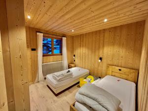 a room with a bed in a wooden room at Résidences Delavay La Cordée in Les Gets