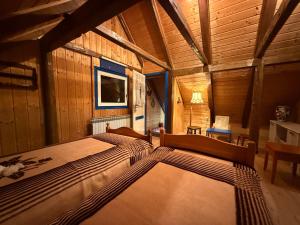 ein Schlafzimmer mit einem großen Bett in einem Holzzimmer in der Unterkunft Kuća Šarenka in Kupjak