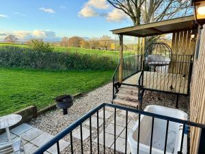 eine Veranda mit Grill, Stühlen und Grill in der Unterkunft Bramley Shepherds Hut - Whimple in Whimple