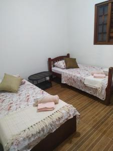 een kamer met twee bedden en twee stoelen bij Refúgio com Hidro, Lareira, Café da Manhã e Vista da Natureza in Santo Antônio do Pinhal +57 foto's