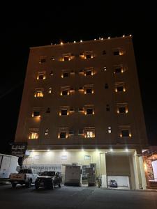 a large building with cars parked in front of it at شقق فرسان العرب المخدومه in Umm Lujj