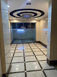 a lobby with a chandelier and a tiled floor at شقق فرسان العرب المخدومه in Umm Lujj