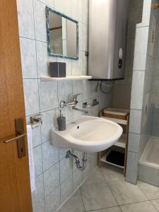 ein Badezimmer mit Waschbecken und Spiegel in der Unterkunft Kuća Šarenka in Kupjak