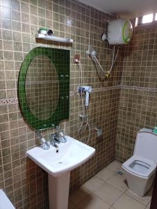 a bathroom with a sink and a mirror and a toilet at Li Tour International Hotel in Ikeja +9 photos