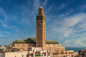 ein großes Gebäude mit einem Uhrturm darüber in der Unterkunft Modern Comfortable Apartment - Corniche Hassan II in Casablanca