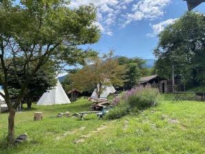 a field with a tent and a picnic table and trees at Little North Campground - Vacation STAY 69019v in Kajikazawa