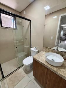 ein Badezimmer mit Toilette, Waschbecken und Dusche in der Unterkunft Casa Moderna & Conforto in Eusébio