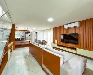 ein Wohnzimmer mit Couch und Flachbildfernseher in der Unterkunft Casa Moderna & Conforto in Eusébio