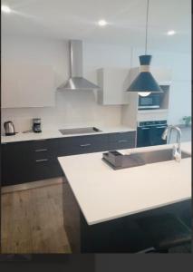 Una cocina con encimera blanca y fregadero. en The Executive Suite, en Puerto España