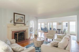 ein Wohnzimmer mit weißen Möbeln und einem Kamin in der Unterkunft Riverfront Retreat in Urbanna with Indoor Hot Tub! in West Irvington