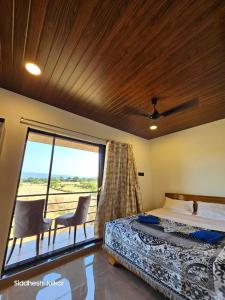 ein Schlafzimmer mit einem Bett und einem großen Fenster in der Unterkunft Anugraha Homestay in Alībāg