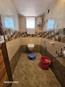 ein kleines Badezimmer mit Toilette und Waschbecken in der Unterkunft Anugraha Homestay in Alībāg + 6 Fotos