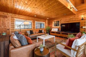 a living room with couches and a flat screen tv at Mtn Views and Fall Colors Panguitch 1-Acre Estate! in Panguitch