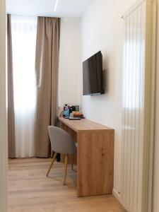 a desk with a television and a chair in a room at VILLA ISABELLA Ospedale Cisanello in Pisa
