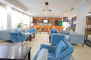 a waiting room with blue chairs and a bar at Hotel Boutique Elmos - Meskel Flower in Addis Ababa
