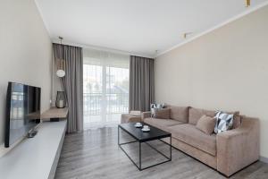 a living room with a couch and a table at BelMare Aqua Resort by Solarento in Międzyzdroje
