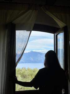Eine Frau, die aus dem Fenster auf die Berge schaut. in der Unterkunft Pie' d'Ulivo in Bosco